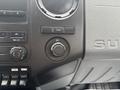 Interior dashboard controls of a 2014 Ford F-550 featuring radio, climate control, and a 12V power outlet