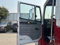 A 1999 Freightliner FL80 truck with the driver's door open showing the interior dashboard and seat