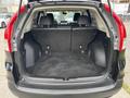 A 2014 Honda CR-V with its rear hatch open revealing an empty cargo area with dark carpeting and no visible items inside