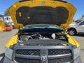 A yellow 2015 RAM 1500 truck with the hood raised revealing the engine compartment and various engine components underneath