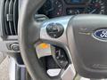 Close-up of the steering wheel of a 2018 Ford Transit-350 featuring control buttons including a circular menu button and several additional function buttons