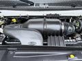 The image shows the engine compartment of a 2013 Ford E-350 with the air intake system in focus featuring a black plastic air duct and various engine components