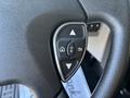 The image shows a close-up of a steering wheel control panel featuring directional buttons and an OK button