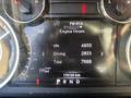 A vehicle dashboard display showing engine hours with readings for idle, driving, and total hours along with mileage and radio station information