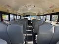 Interior of a 2013 International CE300 school bus with rows of gray seats and an aisle leading to the driver's area