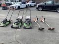 Three Honda Lawnboy mowers and two Stihl line trimmers arranged in a row on a paved surface
