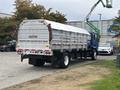 A blue 2017 Autocar Xpert truck with a silver cargo bed featuring a caution sign about frequent stops and wide right turns