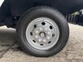 Close-up of a silver wheel on a 2012 Ford E-450 Super Duty showing multiple bolts and a black tire with visible tread