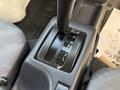 Close-up of the gear shift in a 2008 Suzuki Carry showing P R N D 2 L positions on the gear lever and a textured gray surface beneath