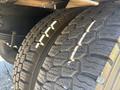 Close-up of the tires on a 2004 Ford F-750 showing heavy tread patterns and distinct grooves on the rubber surface