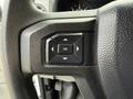 Steering wheel controls of a 2022 Ford E-450 featuring a central "OK" button surrounded by directional arrows