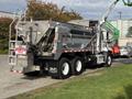 A 2013 Freightliner 114SD truck with a silver body and large rear container designed for heavy-duty work