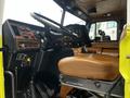The interior of a 1995 Freightliner FL086 featuring a leather driver seat and a dashboard with various gauges and controls