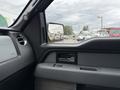 Interior view of a 2014 Ford F-150 showing the driver's side door panel and side mirror