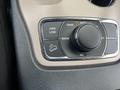 A close-up view of the control panel of a 2015 Jeep Grand Cherokee featuring a dial for drive modes and buttons for 4WD options