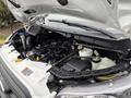 Engine compartment of a 2020 Ford Transit 250 showing various components including the air intake, reservoir, and battery