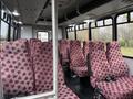 Interior of a 2015 Ford Econoline with rows of red patterned seats arranged in a spacious layout