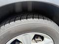 Close-up of a tire from a 2015 Ford Escape showcasing the treads and alloy wheel design