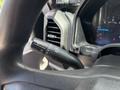 Close-up of the steering column of a 2017 Ford F-550 featuring the turn signal and wiper control stalk with illuminated gauge display in the background