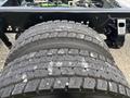 Close-up view of a heavy-duty tire with a rugged tread pattern designed for optimal grip and durability on the road