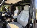 Interior of a 2021 Jeep Gladiator featuring two light-colored leather seats with diamond stitching and a black steering wheel