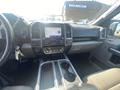 The interior of a 2019 Ford F-150 featuring a dashboard with a touchscreen display climate controls and center console with cup holders