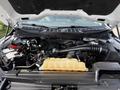 Engine compartment of a 2021 Ford F-150 showing the engine components battery and coolant reservoir