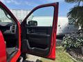 A red 2013 RAM 2500 with an open driver's door showcasing the interior features and controls