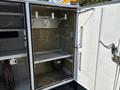 Interior storage area of a 2017 Ford F-550 with hooks on the wall and a shelf showing dirt and wear