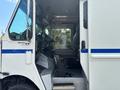 A 2011 Workhorse W62 truck with an open driver's side door showing the interior controls and driver's seat