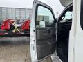 A 2018 Chevrolet Express van with an open driver's side door showing the interior controls and seating area