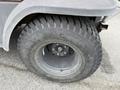 Close-up of a tire from a 2011 Kubota RTV 1140 CPX featuring deep treads and a steel rim