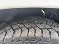 Close-up of a rugged tire tread from a 2016 RAM 1500 showcasing deep grooves and wear patterns on the rubber surface