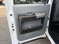 Interior door panel of a 2015 Ford F-550 featuring a silver handle and a storage compartment with multiple slots for small items
