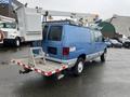 A blue 2006 Ford Econoline van with a bucket lift attached to the roof and a platform at the back for work purposes