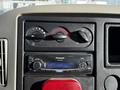 The dashboard of a 2010 International 4300 featuring climate control knobs and a Panasonic car stereo with a digital display