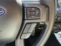 The steering wheel of a 2021 Ford F-250 SD featuring control buttons for volume and audio settings