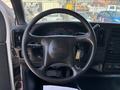 A black steering wheel of a 2007 GMC C4500 TopKick with a key hanging from it and dashboard gauges visible in the background