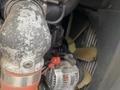 Close-up of a 2010 Vermeer Corporation BC1000XL engine component showing a metal pipe a fan and an alternator