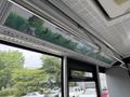 Interior view of a 2018 Grande West Vicinity bus showing overhead signage about green travel initiatives and environmental themes