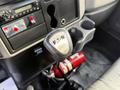 A close-up view of the gear shift lever labeled Eaton inside a 2012 International DuraStar 4300 truck's cabin with a fire extinguisher visible on the floor