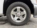 A close-up of a 2012 GMC Canyon's wheel featuring a silver alloy rim with the GMC logo and a rugged tire with an aggressive tread pattern