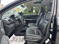Interior of a 2014 Honda CR-V showing black leather seats and dashboard with controls and a sunroof