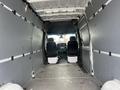 Interior view of a 2025 Mercedes-Benz Sprinter showing empty cargo space with gray walls and two front seats visible in the driver's cabin