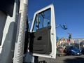 A 2013 International 7500 truck with the driver's side door open showing the interior and the door panel