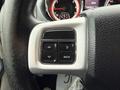 Close-up of a steering wheel control panel with four buttons for navigation and a "Back" button on a 2017 Dodge Grand Caravan
