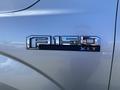 Close-up of the badge on a 2015 Ford F-150 XLT featuring the model name and trim in chrome and black detailing