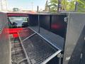 A 2013 RAM 2500 truck bed with a black metal mesh storage compartment featuring multiple shelves for organizing tools or equipment