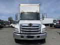 A 2018 Hino 338 truck with a white box body and chrome grille facing the viewer