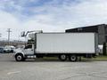 A 2019 Ford F-750 box truck with a white cargo area and a grey cab parked on a lot